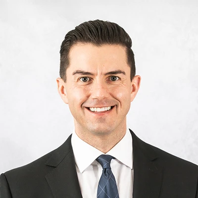 A headshot photo of Dr. Tony Rhodes in a suit