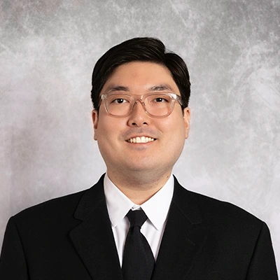 Edward Kim smiling in a black suit.